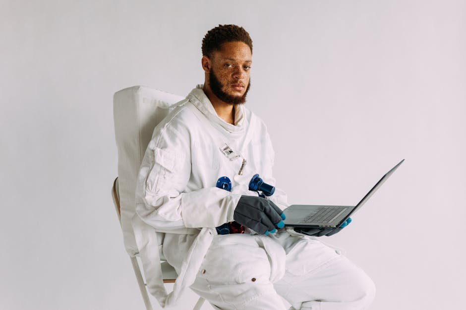A portrait of an astronaut in a space suit holding a laptop, symbolizing technology and exploration.