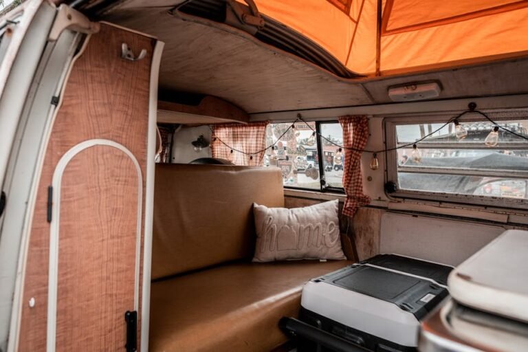 A vintage campervan interior featuring retro decor and warm lighting, perfect for travel lovers.