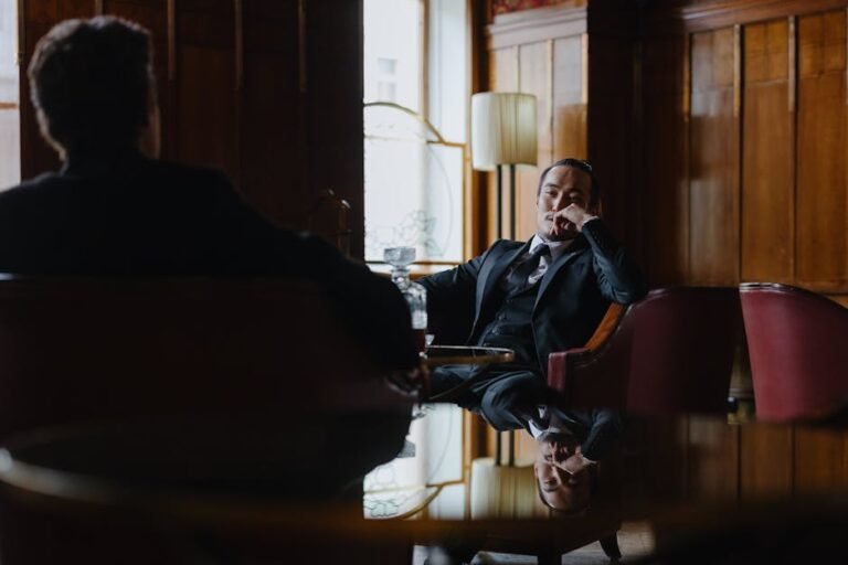 Elegantly dressed men in a sophisticated business setting with wood paneling.