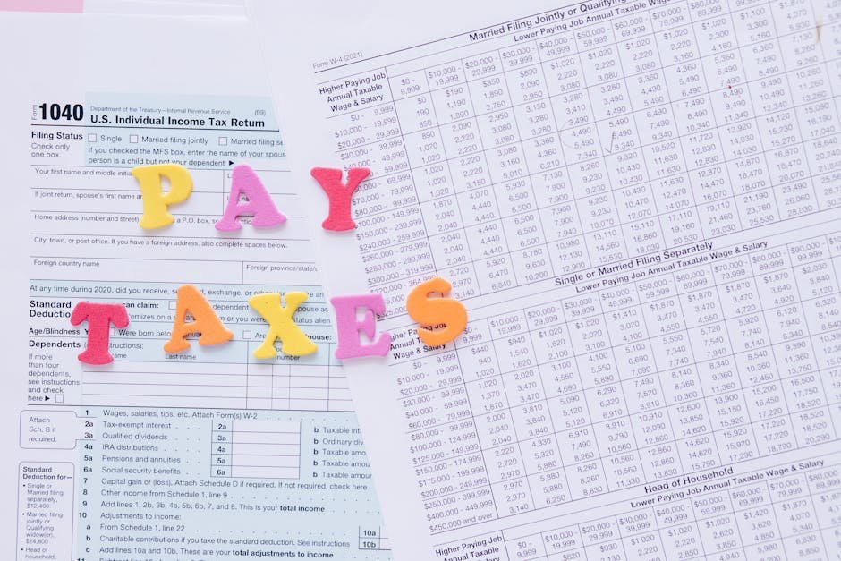 Close-up of U.S. tax forms with colorful 'PAY TAXES' letters emphasizing financial deadlines.