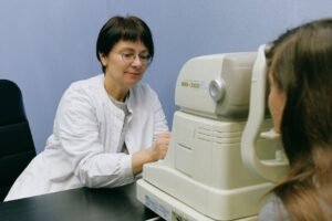 A healthcare professional conducts an eye exam using advanced technology in a clinical setting.