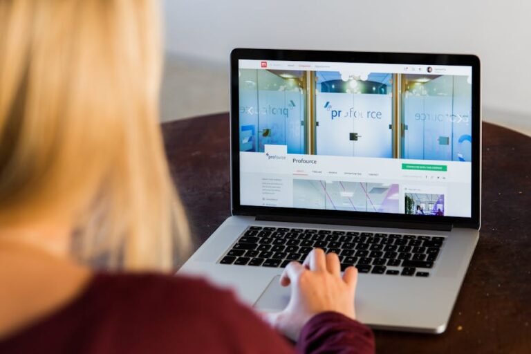 Woman working on a laptop, viewing a business website, in a professional indoor setting.